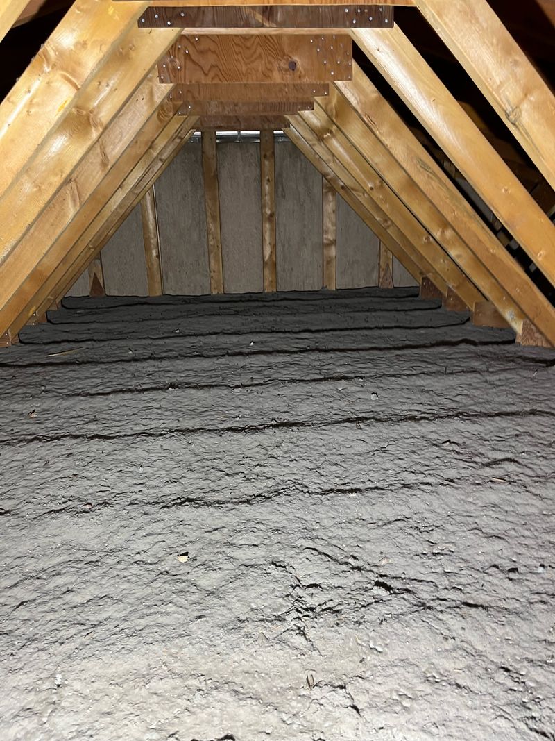 Attic with old settled dark insulation before blow-in work